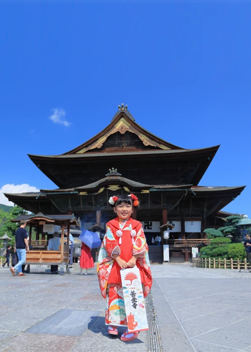 善光寺 本堂で祝う七五三 ～着物でご祈願&七五三写真撮影～ イメージ画像06｜長野県長野市にある善光寺にて3歳女の子、千歳飴を持って七五三写真撮影｜2024年10月5日(土)～ 善光寺 本堂～国宝 善光寺本堂で祝う七五三｜年間ご利用者数2万人を超えるスタジオシャレニーの凄腕カメラマンが素敵な写真を撮影します！七五三着物ﾚﾝﾀﾙ1拍2日、着付、ヘアメイク、七五三のご祈願、七五三写真撮影、お写真、データがセットのお得な内容に！